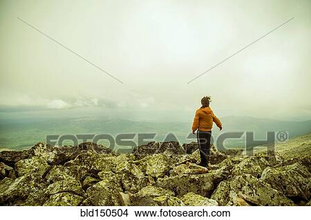 Caucasian hiker enjoying scenic view from rocky hilltop View Large Photo Image Picture - Caucasian hiker enjoying scenic view from rocky hilltop. Fotosearch