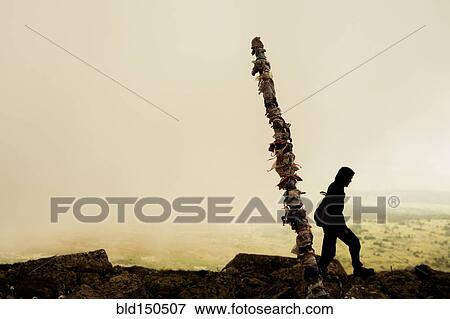 Stock Photo - Caucasian hiker walking on rocky hilltop. Fotosearch