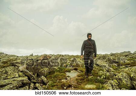 Caucasian hiker walking on rocky hillside View Large Photo Image Stock Photograph - Caucasian hiker walking on rocky hillside. Fotosearch