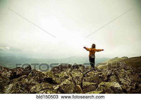 Caucasian hiker with arms outstretched on rocky hilltop View Large Photo Image Stock Image - Caucasian hiker with arms outstretched on rocky hilltop. Fotosearch