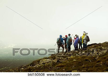 Caucasian hikers standing on rocky hilltop View Large Photo Image Stock Photo - Caucasian hikers standing on rocky hilltop. Fotosearch