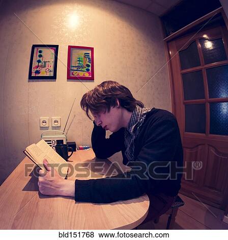 Caucasian man reading at table View Large Photo Image Stock Photo - Caucasian man reading at table. Fotosearch
