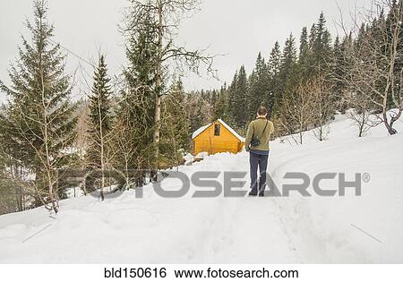 Stock Photograph - Caucasian man standing on snowy hillside. Fotosearch