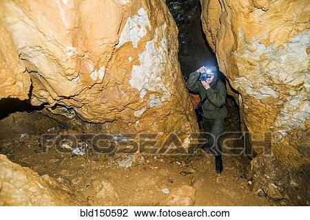Caucasian man taking photograph in rock formation cave View Large Photo Image Stock Image - Caucasian man taking photograph in rock formation cave. Fotosearch
