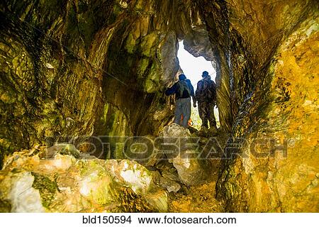 Caucasian men exploring rock formation cave View Large Photo Image Picture - Caucasian men exploring rock formation cave. Fotosearch