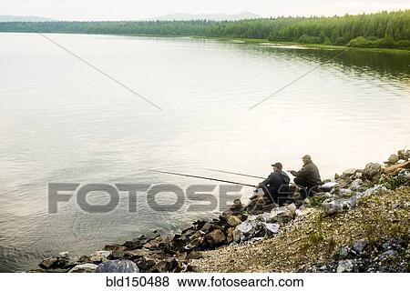 Caucasian men fishing in rural lake View Large Photo Image Stock Photo - Caucasian men fishing in rural lake. Fotosearch