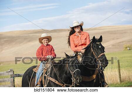 Caucasian mother and son on horseback on grassy hill View Large Photo Image Picture - Caucasian mother and son on horseback on grassy hill. Fotosearch