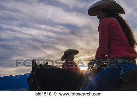 Caucasian mother and son riding horses at sunset View Large Photo Image Stock Photo - Caucasian mother and son riding horses at sunset. Fotosearch