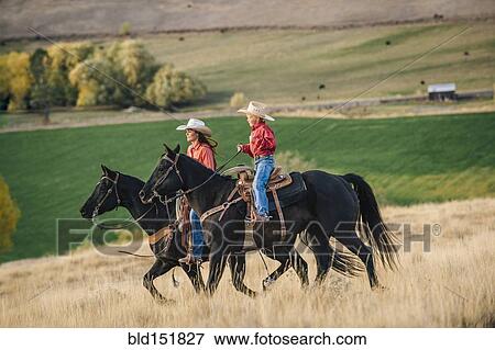 Caucasian mother and son riding horses in grassy field View Large Photo Image Stock Photo - Caucasian mother and son riding horses in grassy field. Fotosearch