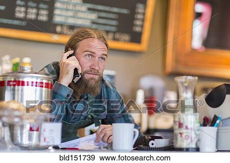 Caucasian server using telephone in cafe View Large Photo Image Stock Photo - Caucasian server using telephone in cafe. Fotosearch