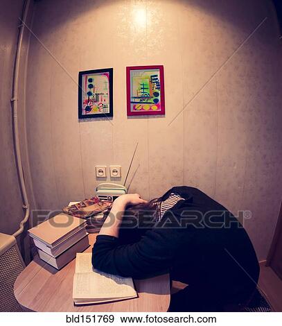 Stock Photo - Caucasian student sleeping at table. Fotosearch