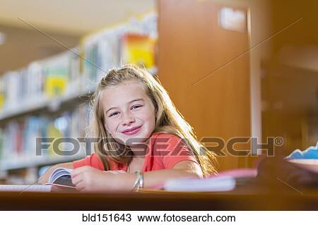 Caucasian student smiling at desk in library View Large Photo Image Stock Image - Caucasian student smiling at desk in library. Fotosearch