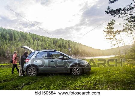 Caucasian tourists unloading car in remote landscape View Large Photo Image Picture - Caucasian tourists unloading car in remote landscape. Fotosearch