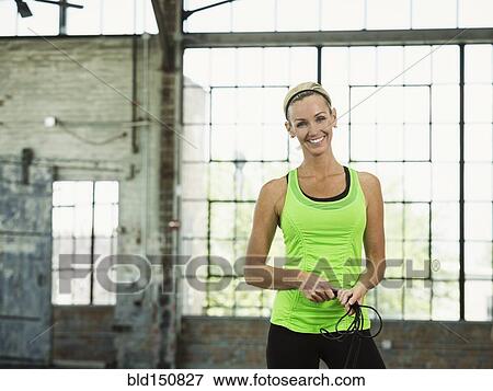 Caucasian woman holding jump rope in warehouse View Large Photo Image Stock Photo - Caucasian woman holding jump rope in warehouse. Fotosearch