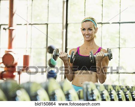 Caucasian woman lifting weights in gym View Large Photo Image Picture - Caucasian woman lifting weights in gym. Fotosearch