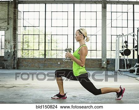 Caucasian woman lifting weights in warehouse gym View Large Photo Image Picture - Caucasian woman lifting weights in warehouse gym. Fotosearch