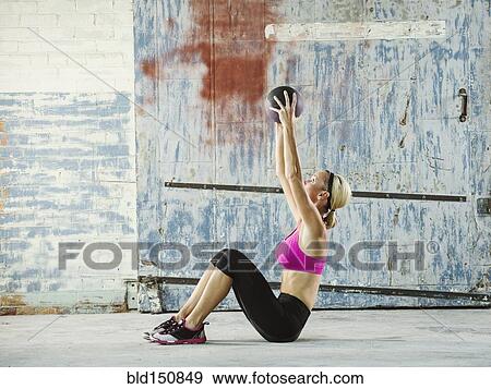 Caucasian woman lifting weights in warehouse View Large Photo Image Stock Photo - Caucasian woman lifting weights in warehouse. Fotosearch
