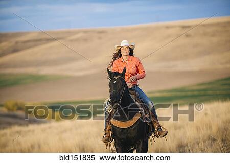 Caucasian woman riding horse in grassy field View Large Photo Image Stock Photography - Caucasian woman riding horse in grassy field. Fotosearch