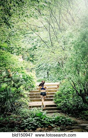 Caucasian woman running on staircase in park View Large Photo Image Stock Photo - Caucasian woman running on staircase in park. Fotosearch