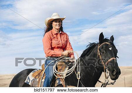 Caucasian woman smiling on horse View Large Photo Image Stock Photo - Caucasian woman smiling on horse. Fotosearch
