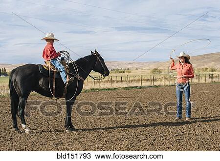 Caucasian woman teaching boy to use lasso on ranch View Large Photo Image Stock Image - Caucasian woman teaching boy to use lasso on ranch. Fotosearch