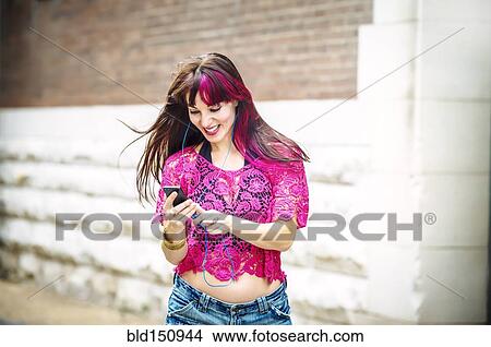 Picture - Caucasian woman using cell phone outdoors. Fotosearch
