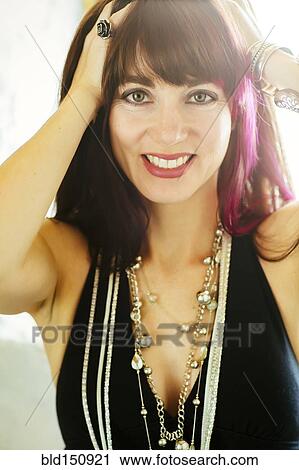 Stock Image - Caucasian woman with dyed hair smiling. Fotosearch