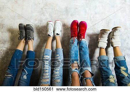 Caucasian women admiring their sneakers against wall View Large Photo Image Stock Image - Caucasian women admiring their sneakers against wall. Fotosearch