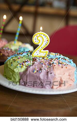 Stock Photo - Close up of birthday cake with number two candle. Fotosearch