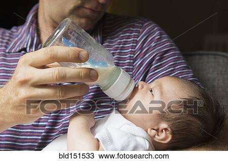 Close up of father bottle feeding baby View Large Photo Image Stock Image - Close up of father bottle feeding baby. Fotosearch