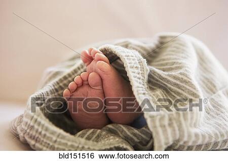 Stock Photograph - Close up of feet of mixed race baby in blanket. Fotosearch