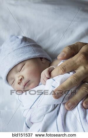 Close up of newborn baby holding finger of father View Large Photo Image Stock Photo - Close up of newborn baby holding finger of father. Fotosearch