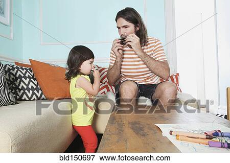 Stock Photo - Father and daughter playing in living room. Fotosearch