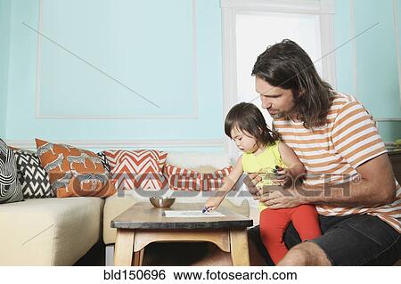Stock Photograph - Father and daughter playing in living room. Fotosearch