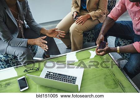 Stock Photography - High angle view of business people using laptop in office. Fotosearch