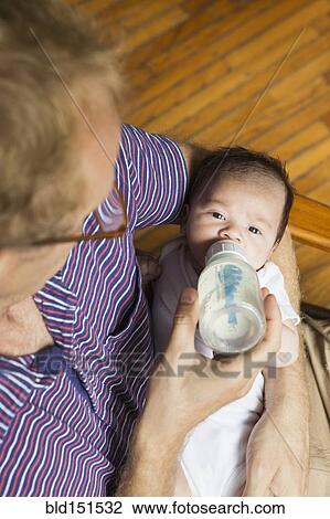 High angle view of father bottle feeding baby View Large Photo Image Stock Image - High angle view of father bottle feeding baby. Fotosearch