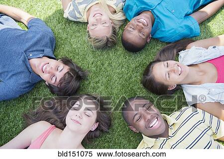 High angle view of teenagers laying on grass lawn View Large Photo Image Stock Photography - High angle view of teenagers laying on grass lawn. Fotosearch