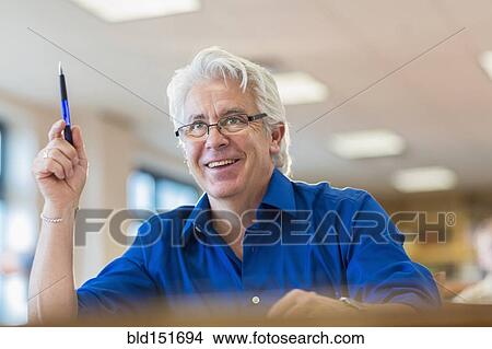 Hispanic adult student raising his hand in class View Large Photo Image Picture - Hispanic adult student raising his hand in class. Fotosearch