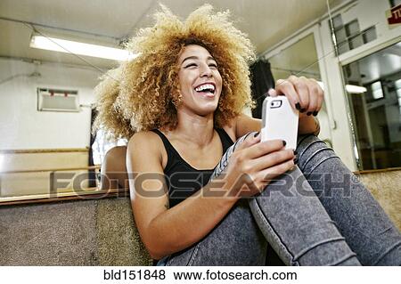 Stock Photo - Hispanic dancer using cell phone in studio. Fotosearch