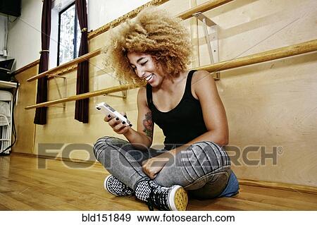 Hispanic dancer using cell phone in studio View Large Photo Image Stock Photo - Hispanic dancer using cell phone in studio. Fotosearch