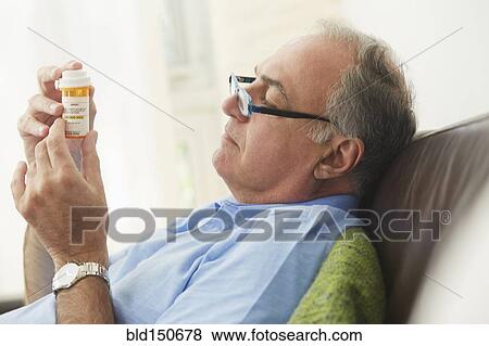 Hispanic man reading prescription medication bottle View Large Photo Image Stock Photo - Hispanic man reading prescription medication bottle. Fotosearch