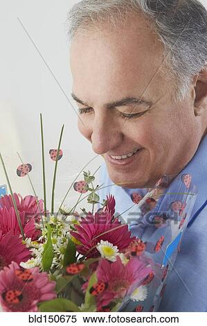 Hispanic man smelling bouquet of flowers View Large Photo Image Stock Photography - Hispanic man smelling bouquet of flowers. Fotosearch
