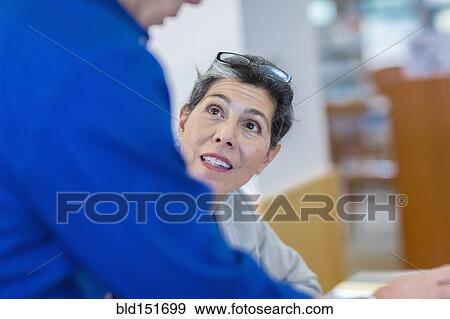 Hispanic teacher helping adult student in library View Large Photo Image Stock Photo - Hispanic teacher helping adult student in library. Fotosearch