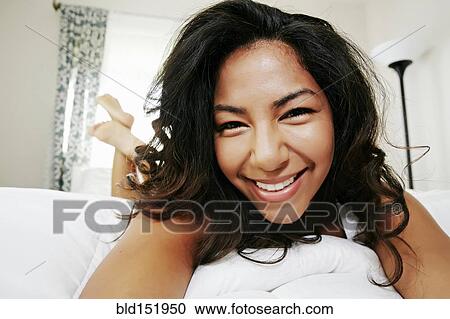 Hispanic woman laying on bed View Large Photo Image Stock Image - Hispanic woman laying on bed. Fotosearch