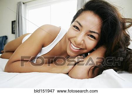 Hispanic woman laying on bed View Large Photo Image Stock Photo - Hispanic woman laying on bed. Fotosearch