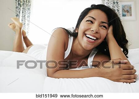 Hispanic woman laying on bed View Large Photo Image Stock Photo - Hispanic woman laying on bed. Fotosearch