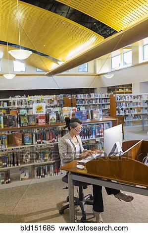 Hispanic woman using computer in library View Large Photo Image Stock Photography - Hispanic woman using computer in library. Fotosearch