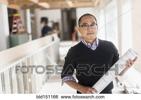 Stock Photograph - Korean architect carrying blueprints. Fotosearch
