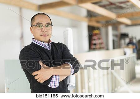 Stock Photography - Korean businessman standing with arms crossed. Fotosearch