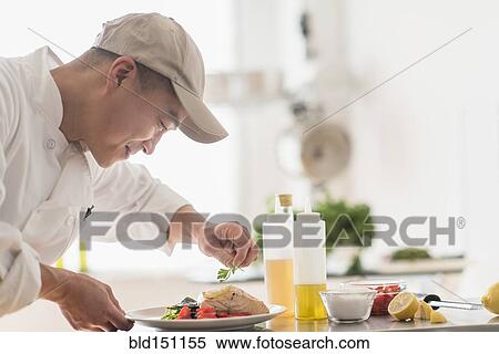 Stock Photography - Korean chef preparing meal in kitchen. Fotosearch